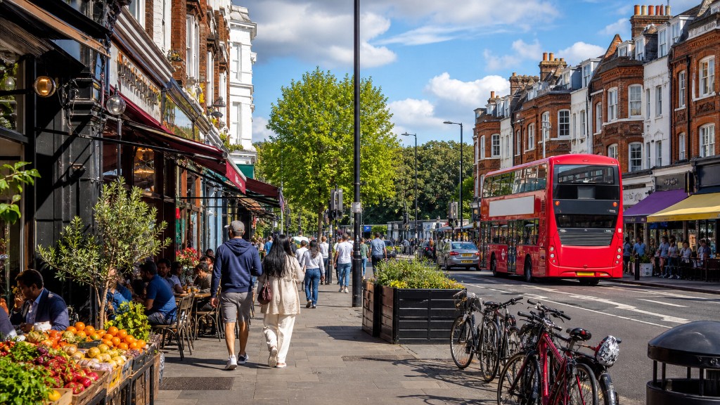 Tooting: busy high street with cafés, fruit stall, red bus, brick terraces and trees